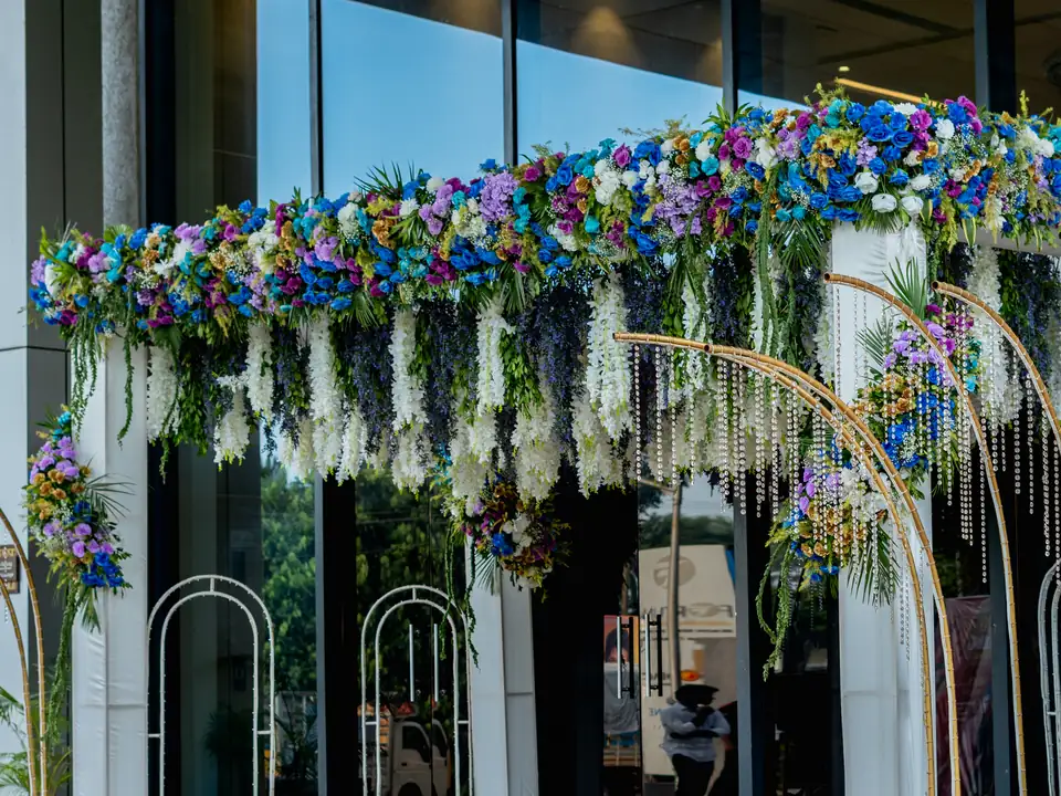 Hanging white wisteria with blue and purple flowers over a reception entrance