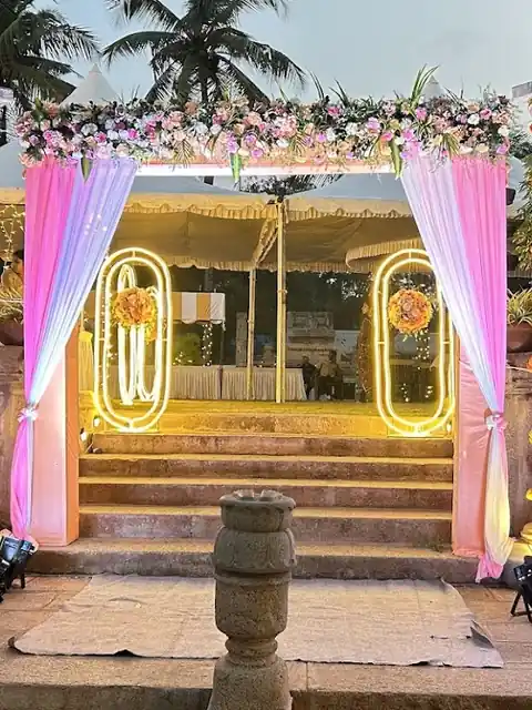 Engagement entrance with pink drapes, a floral arch and a welcome sign
