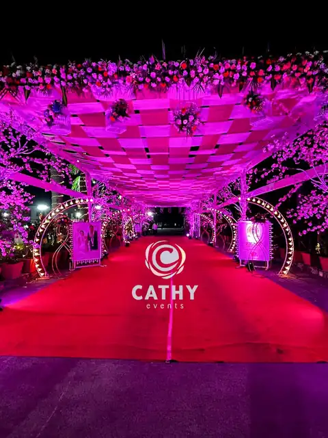 Pink and purple lit tunnel entrance over a red carpet